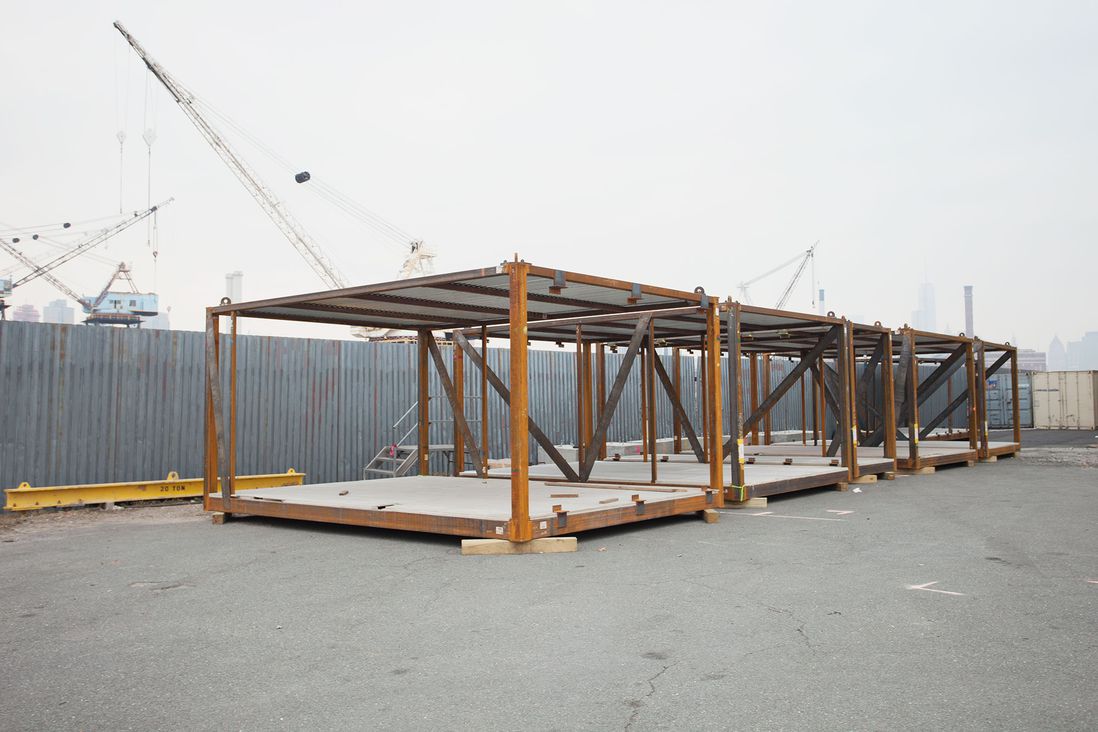 These modular frames are built down south and shipped up to the factory on flatbed trucks. They wait outside until they're ready to be outfitted inside. The metal frame actually forms the support skeleton of the building when all the pieces go together.